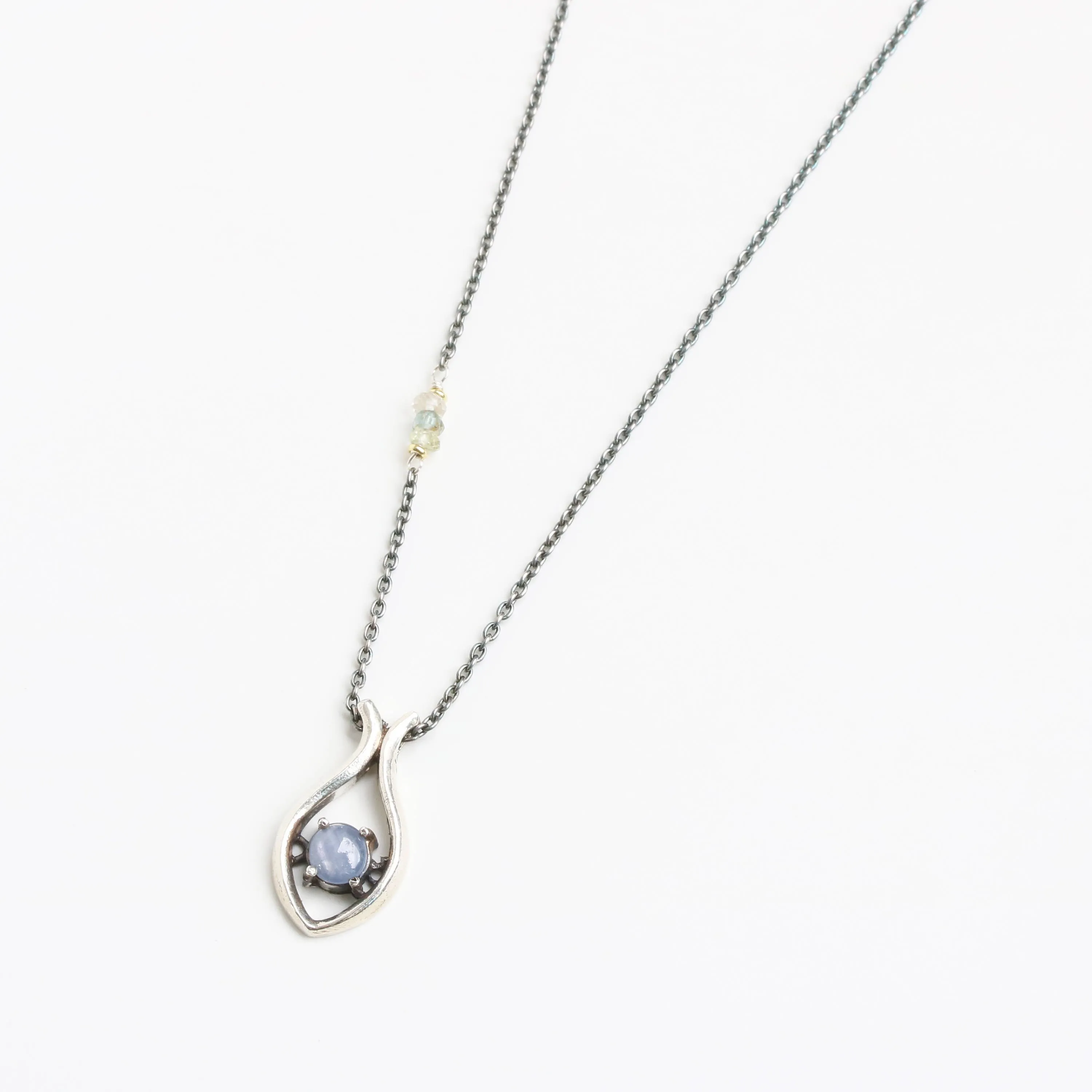Silver fish shape necklace and cabochon star blue sapphire at the center with aquamarine beads secondary on oxidized sterling silver chain